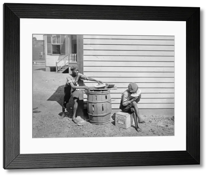Framed Print : Boy eating watermelon while his friend steals a piece in Ame Framed Print : Boy eating watermelon while his friend steals a piece in Ame