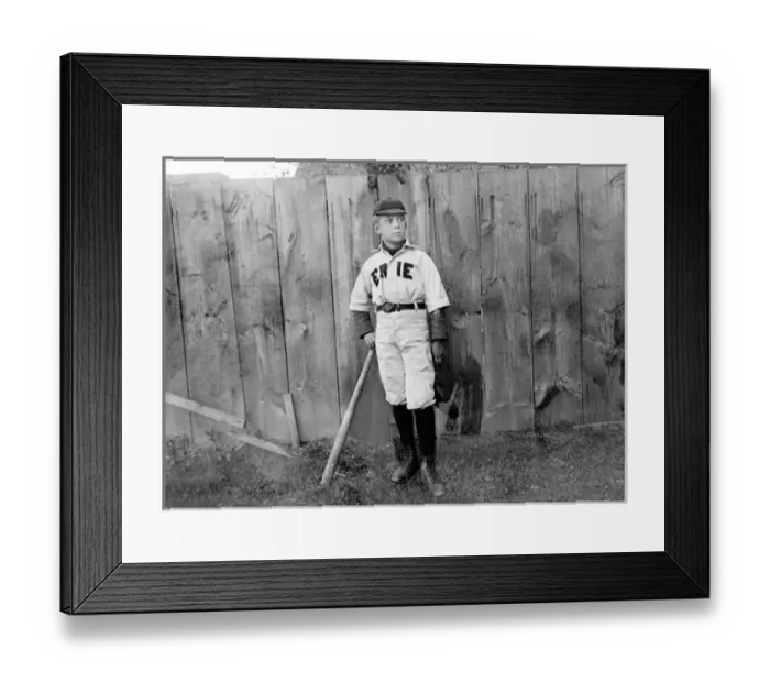 Framed Print : A boy in baseball uniform by a fence in America Framed Print : A boy in baseball uniform by a fence in America