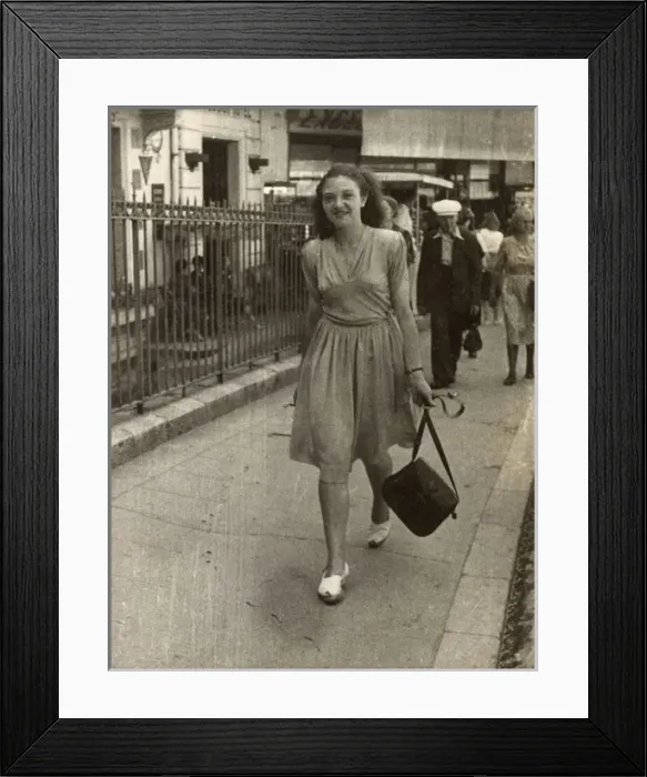 Framed Print : Young lady strolling confidently along, swinging her handbag Framed Print : Young lady strolling confidently along, swinging her handbag