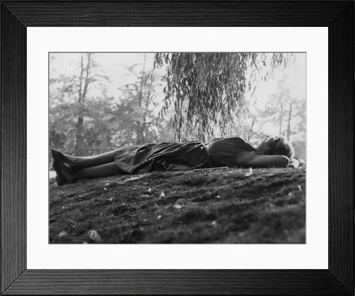 Framed Print : Woman relaxing on grass under a tree Framed Print : Woman relaxing on grass under a tree