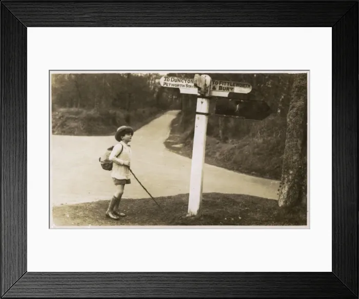 Framed Print : Petworth - Young boy checking his directions on a signpost Framed Print : Petworth - Young boy checking his directions on a signpost