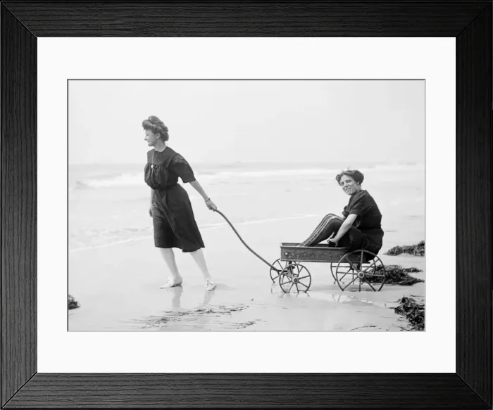 Framed Print : Two women in period bathing costumes on the beach in America Framed Print : Two women in period bathing costumes on the beach in America