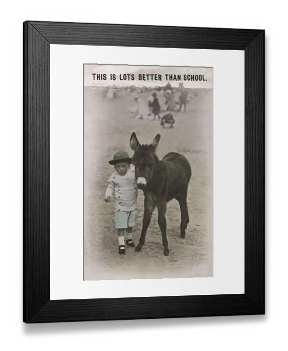 Framed Print : Young boy with a baby donkey on a British beach Framed Print : Young boy with a baby donkey on a British beach