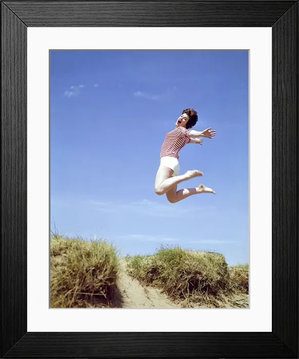 Framed Print : Young woman leaps up from a sand dune Framed Print : Young woman leaps up from a sand dune