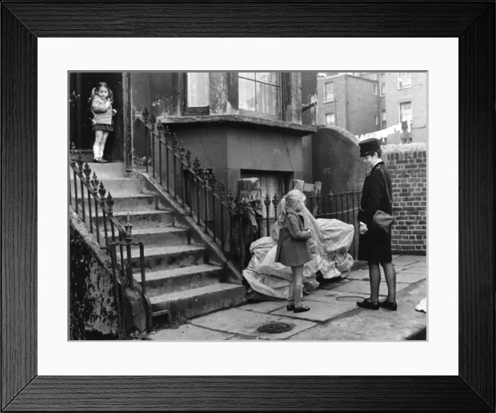 Framed Print : Woman police officer outside a house with two children Framed Print : Woman police officer outside a house with two children