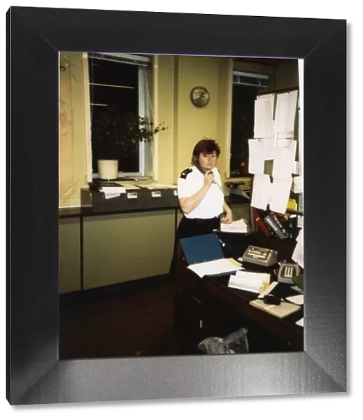 Woman police officer on the phone in a police station