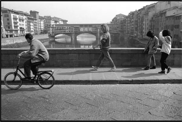 Cyclist, pedestrians, view of Ponte Vecchio, Florence, Italy
