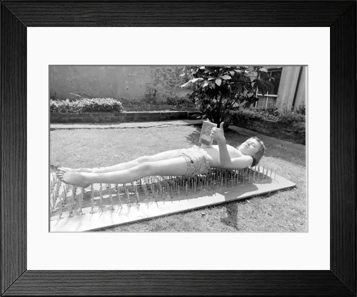 Framed Print : Boy stuntman on bed of nails Framed Print : Boy stuntman on bed of nails