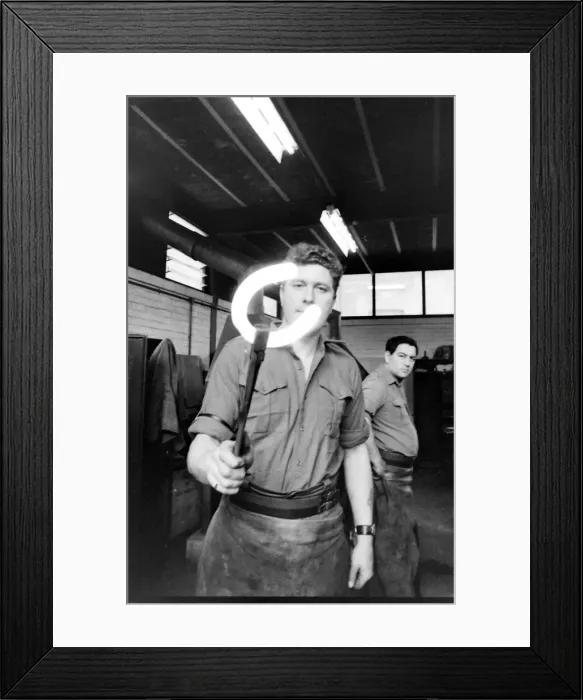 Framed Print : Blacksmith holding up a hot horseshoe Framed Print : Blacksmith holding up a hot horseshoe