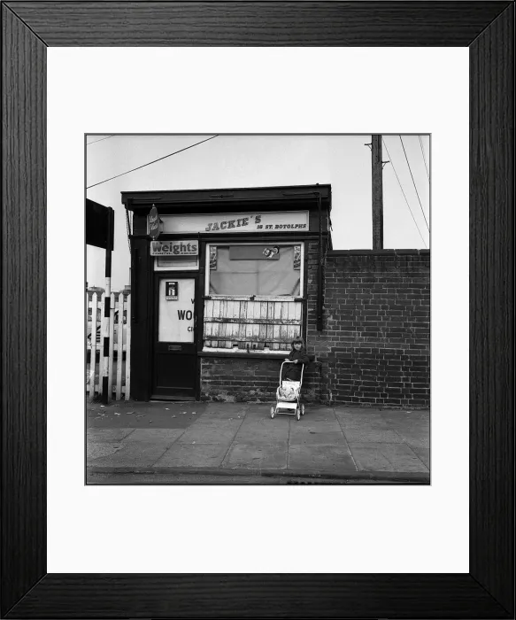 Framed Print : Little girl withy pushchair outside shop Framed Print : Little girl withy pushchair outside shop