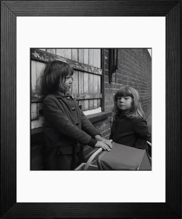 Framed Print : Girls with toy pram in the street Framed Print : Girls with toy pram in the street