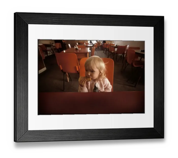 Framed Print : A Little girl eating toast in a cafe Framed Print : A Little girl eating toast in a cafe