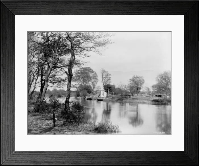 Framed Print : A scene of a river with small boats in the middle distance Framed Print : A scene of a river with small boats in the middle distance