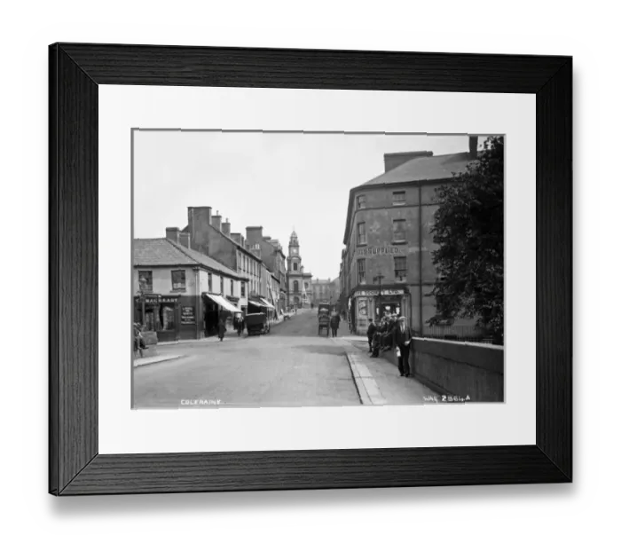 Framed Print : Coleraine - a street scene with shop fronts, motor cars and people, taken Framed Print : Coleraine - a street scene with shop fronts, motor cars and people, taken