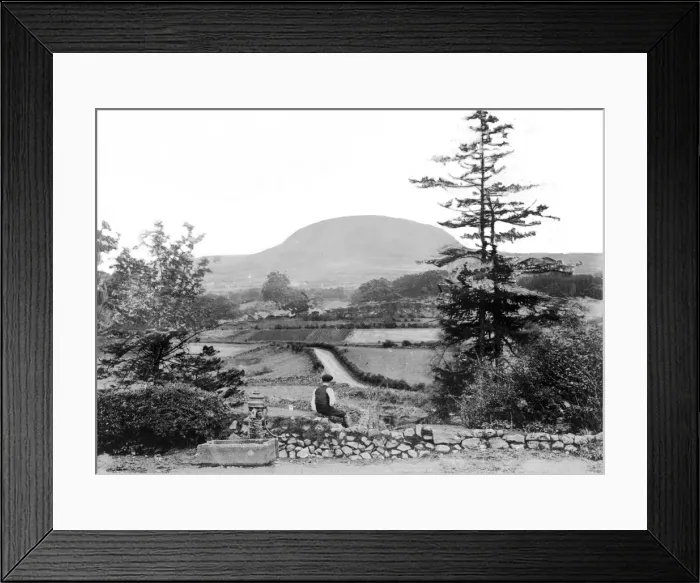 Framed Print : Slemish - a view of Slemish with a man in the foreground sitting beside a water pump Framed Print : Slemish - a view of Slemish with a man in the foreground sitting beside a water pump