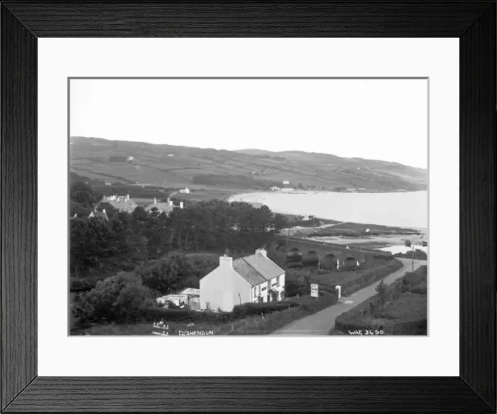Framed Print : Cushendun - an elevated view looking down on the village and stone bridge and bay Framed Print : Cushendun - an elevated view looking down on the village and stone bridge and bay