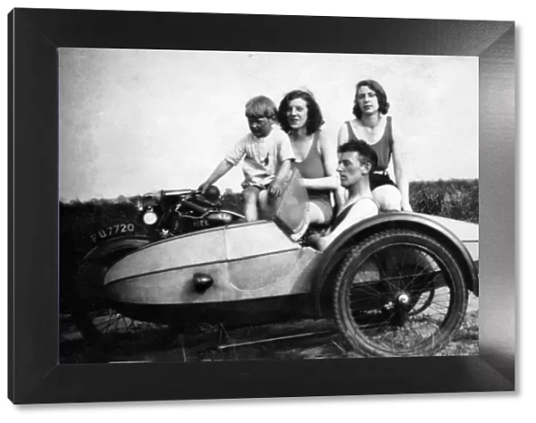 Four people on a 1929 Ariel motorcycle & sidecar