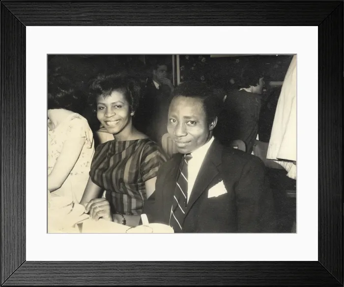 Framed Print : African couple, smiling at the camera at a dinner at the Con Framed Print : African couple, smiling at the camera at a dinner at the Con
