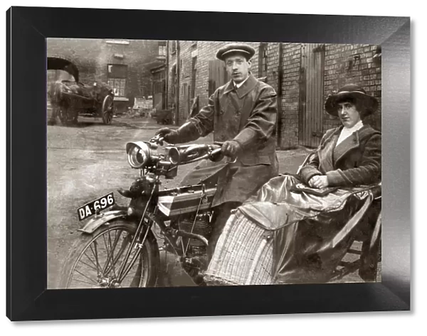 Lady & gentleman sitting on a 1910 Triumph motorcycle