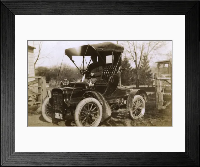 Framed Print : Man at the wheel of an early car, USA