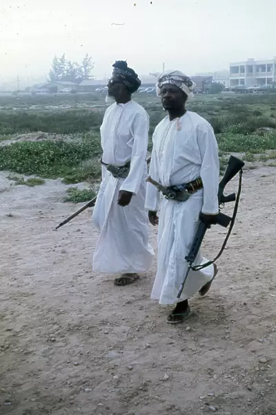Omani elders wearing Khanjar and carrying rifles in Oman