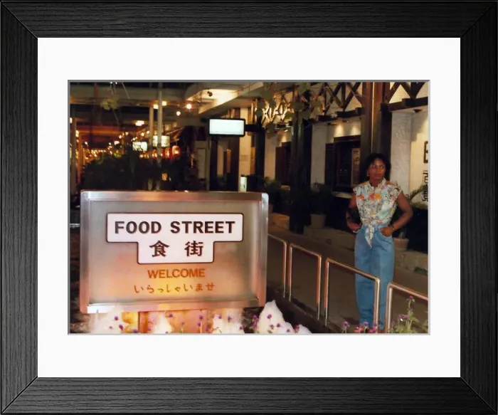 Framed Print : British Caribbean woman stands by Food Street sign, Hong K Framed Print : British Caribbean woman stands by Food Street sign, Hong K
