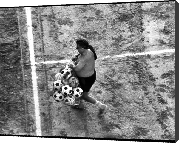Man with footballs on training pitch, Spain