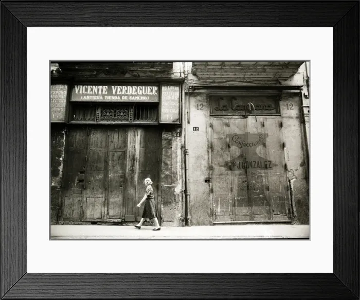 Framed Print : Woman walking in front of boarded up shops, Valencia, Spain Framed Print : Woman walking in front of boarded up shops, Valencia, Spain