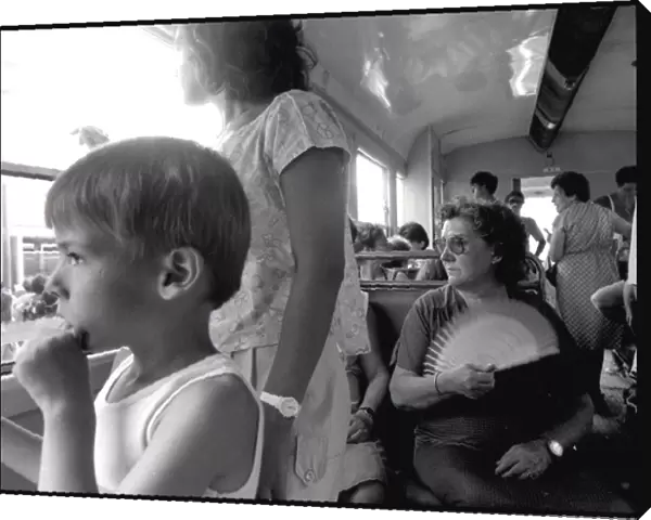 Small boy lady with fan on bus, Valencia, Spain