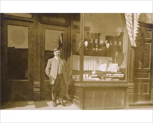 Owner standing outside jewellers shop, USA