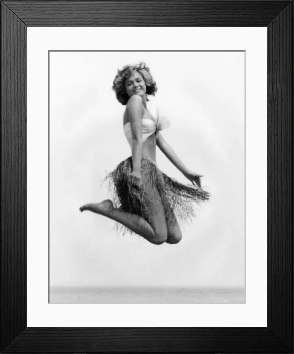 Framed Print : Young woman jumping in a grass skirt, West Country Framed Print : Young woman jumping in a grass skirt, West Country