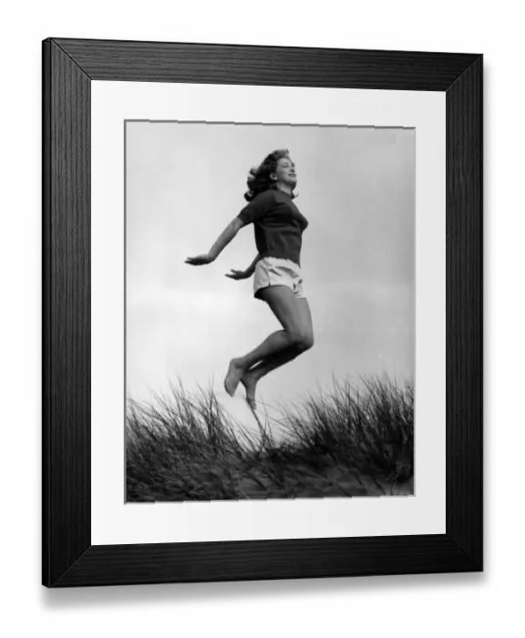 Framed Print : Woman in shorts and top jumping in sand dunes Framed Print : Woman in shorts and top jumping in sand dunes