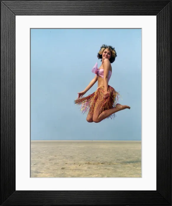 Framed Print : Young woman jumping in a grass skirt, West Country Framed Print : Young woman jumping in a grass skirt, West Country