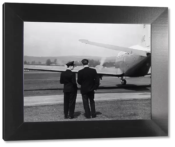 Scene at Exeter Airport, with two men and a plane