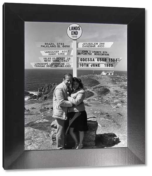 Honeymoon couple and signpost at Lands End, Cornwall