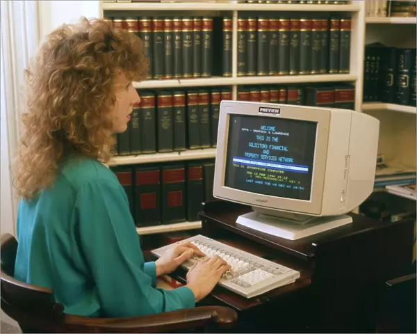 Young woman working at a computer in a solicitors office