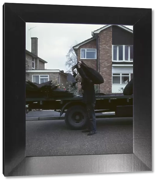 Coalman delivering coal in a street of houses