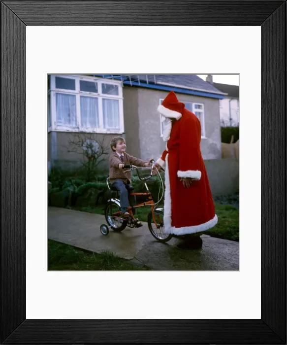 Framed Print : Father Christmas chats to boy on bike Framed Print : Father Christmas chats to boy on bike