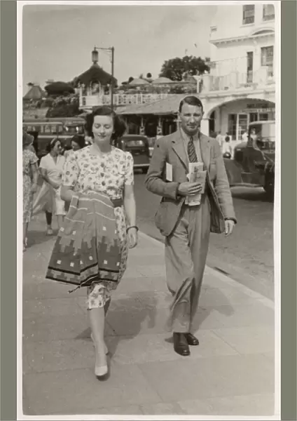 Stylish couple on holiday in Paignton walk along seafront