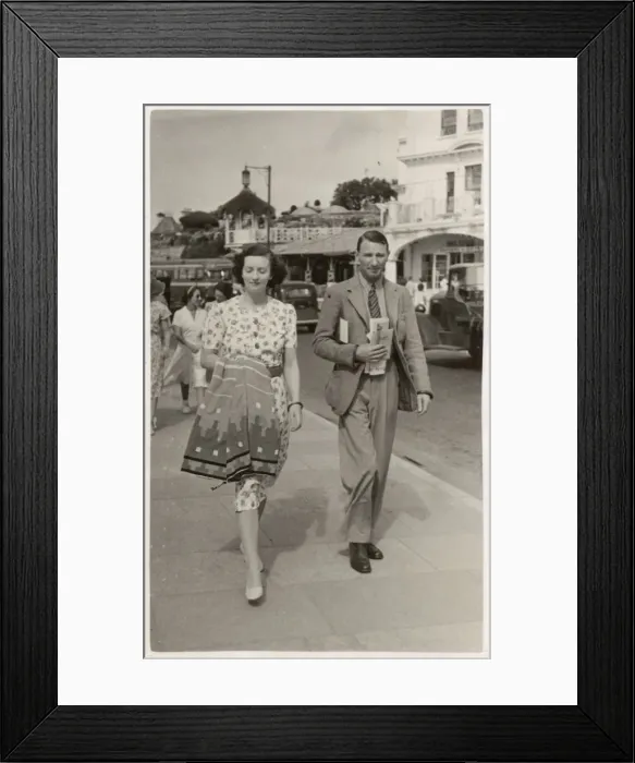 Framed Print : Stylish couple on holiday in Paignton walk along seafront