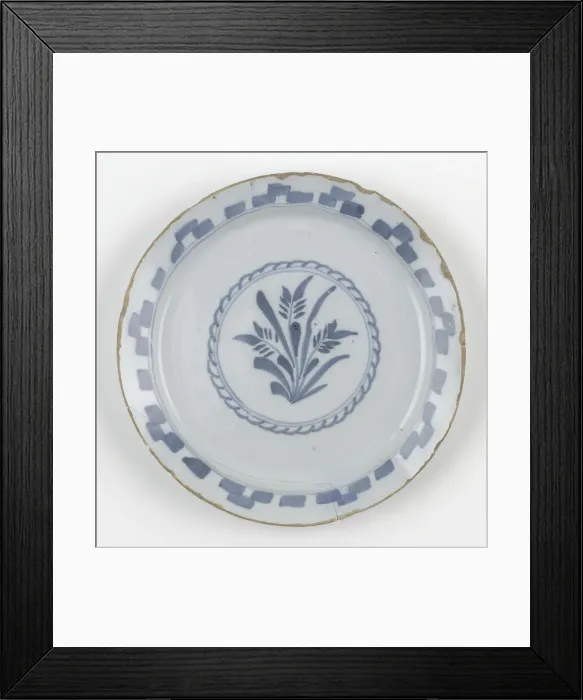 Framed Print : Plate. Tin-glazed earthenware plate painted in blue with a central design Framed Print : Plate. Tin-glazed earthenware plate painted in blue with a central design