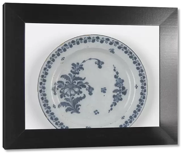 Plate. Tin-glazed earthenware plate painted in a blue floral design with a foliate border