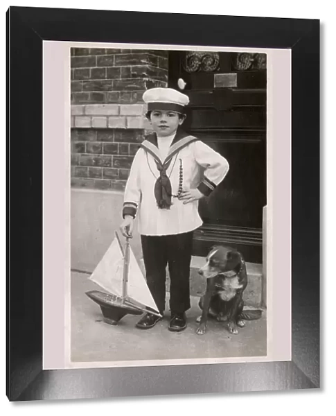 Young lad in sailor suit with pet dog and model ship