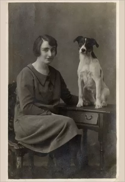 A lady and her dog pose for a studio portrait