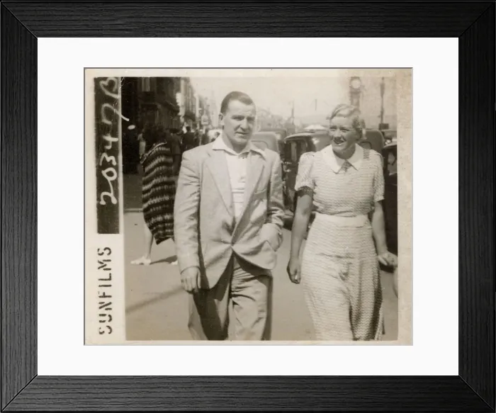 Framed Print : Couple strolling along the front on holiday in Weymouth Framed Print : Couple strolling along the front on holiday in Weymouth