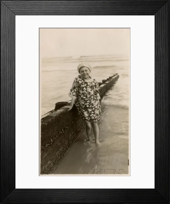 Framed Print : Young girl at the seaside in floral dress and bathing cap Framed Print : Young girl at the seaside in floral dress and bathing cap