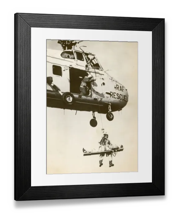 Framed Print : A Royal Air Force Westland Whirlwind winching a stretcher Framed Print : A Royal Air Force Westland Whirlwind winching a stretcher