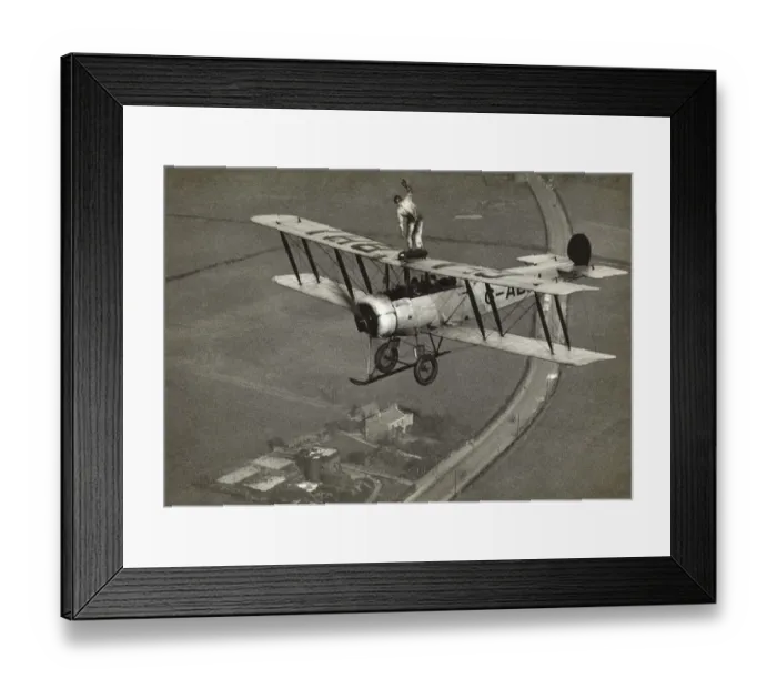 Framed Print : Avro 504K. Wing-Walking on an Avro 504K Flying over Fields Date: 1920s Framed Print : Avro 504K. Wing-Walking on an Avro 504K Flying over Fields Date: 1920s