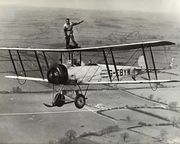 Avro 504K. Wing-Walking on an Avro 504K Flying over Fields Date: 1920s