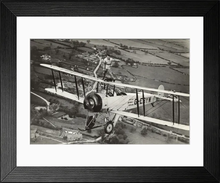 Framed Print : Avro 504K. Wing-Walking on an Avro 504K Flying over Fields Date: 1920s Framed Print : Avro 504K. Wing-Walking on an Avro 504K Flying over Fields Date: 1920s
